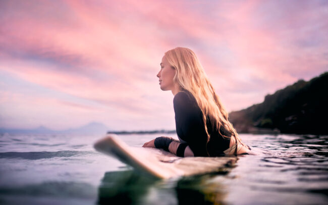 Lifestyle Fotografie mit Surferin Melanie auf Bali beim Sonnenaufgang mit einem Surfboard von Dylan